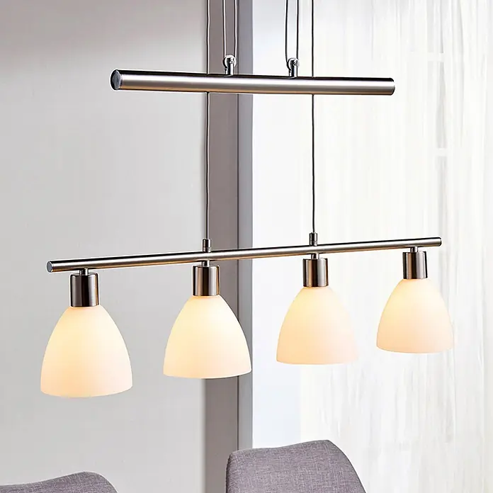 Lindby Pendelleuchte Simeon - L x B x H: 72,5 x 13 x 12 cm, weiß, nickel matt, E14 - Pendelleuchte aus gebürstetem Metall mit vier satinierten Glasschirmen über einem Tisch.