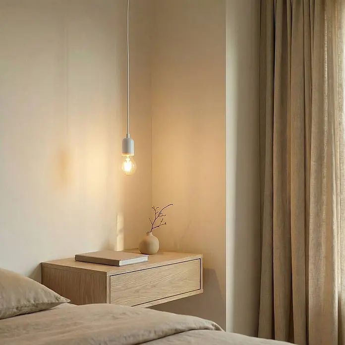 Lindby Pendelleuchte Hattie - weiß / opal, weiß, E27 - Minimalistische weiße Pendelleuchte mit sichtbarer Glühbirne, die einen Holznachttisch in einem gemütlichen Schlafzimmer beleuchtet.