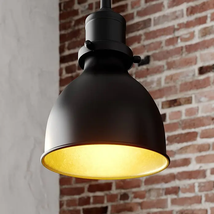 Lindby Pendelleuchte Jasminka - L x B x H: 97,5 x 15,5 x 20 cm, schwarz, Schwarz, gold, E27 - Eine schwarze Pendelleuchte mit goldener Innenseite spendet warmes Licht vor einer rustikalen Ziegelwand.