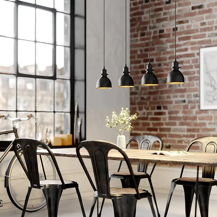 Lindby Pendelleuchte Jasminka - L x B x H: 97,5 x 15,5 x 20 cm, schwarz, Schwarz, gold, E27 - Vier schwarze Pendelleuchten im Industriestil mit goldenen Innenseiten hängen über einem Holzesstisch.