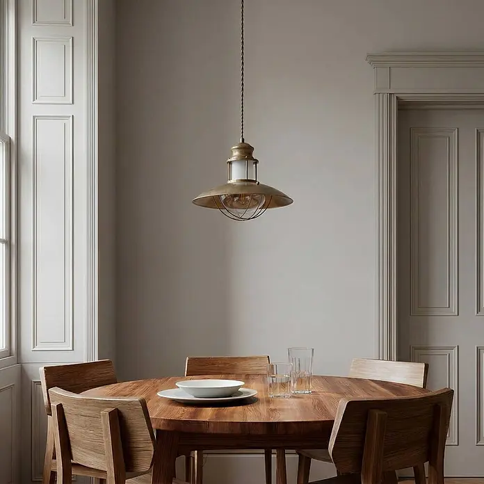 Lindby Pendelleuchte Louisanne - braun / rost, braun, klar, satiniert, E27 - Messing-Pendelleuchte mit breitem Schirm und vergitterter Glühbirne über einem Holztisch, zeigt Einsatz im Essbereich.
