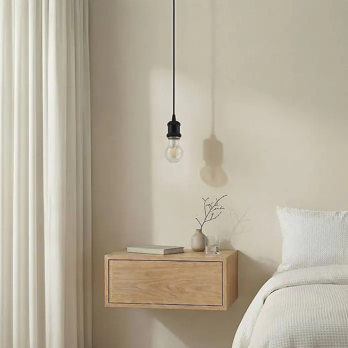 Lindby Pendelleuchte Hattie - L x B x H: 5 x 5 x 6,5 cm, schwarz, Schwarz, E27 - Hellholz-Schwebetisch mit Schublade, mit Buch und Vase dekoriert, neben einem Bett und unter einer minimalistischen schwarzen Hängeleuchte.