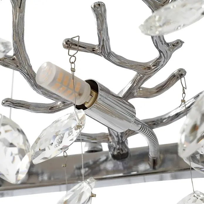 Lucande Pendelleuchte Bellora - L x B x H: 101 x 45 x 32 cm, klar / transparent, chrom, transparent, G9 - Nahaufnahme einer Chrom-Leuchte mit geweihartigen Ästen, funkelnden Kristallen und einer sichtbaren LED-Birne.