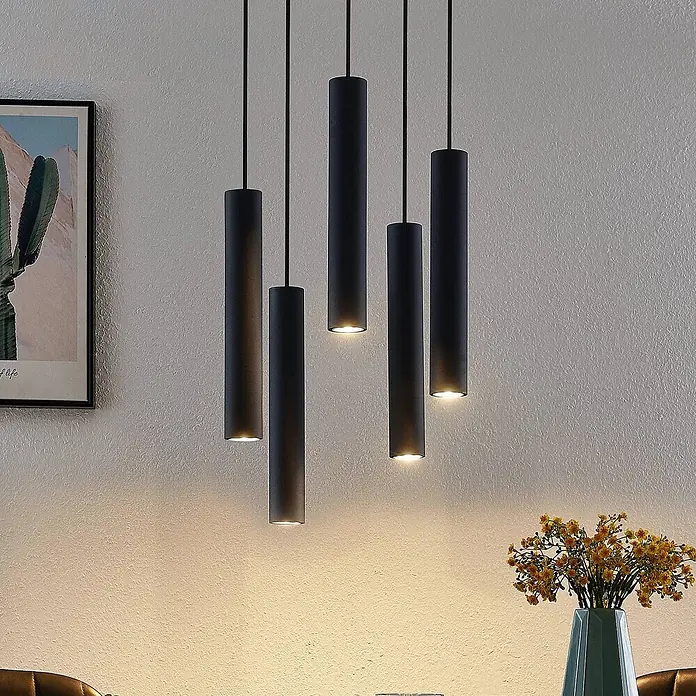 Lindby Pendelleuchte Sanad - L x B x H: 40 x 40 x 40 cm, schwarz, sandSchwarz, GU10 - Fünf schwarze zylindrische Pendelleuchten hängen in verschiedenen Höhen und beleuchten den Raum darunter mit warmem Licht.