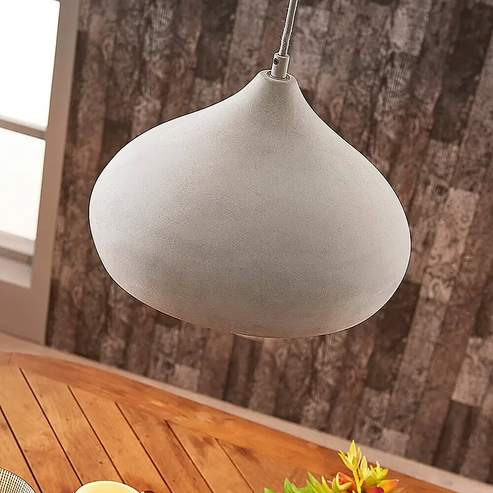 Lindby Pendelleuchte Morton - alu / grau / zink, betongrau, E27 - Hellgraue, tropfenförmige Hängeleuchte aus Beton über einem Holztisch.