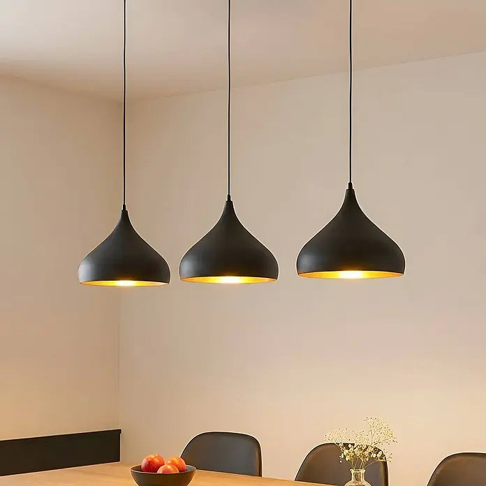 Lindby Pendelleuchte Elamira - L x B x H: 133 x 31 x 150 cm, schwarz, Schwarz, gold, E27 - Drei schwarze Pendelleuchten mit goldener Innenseite beleuchten einen Esstisch.