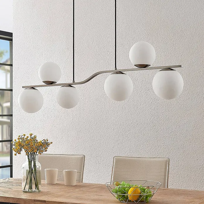 Lindby Pendelleuchte Avalyn - L x B x H: 110 x 16 x 32 cm, weiß, nickel satiniert, E14 - Moderne Pendelleuchte mit sechs kugelförmigen, mattierten Glasschirmen in Altmessing-Optik, über einem Esstisch.