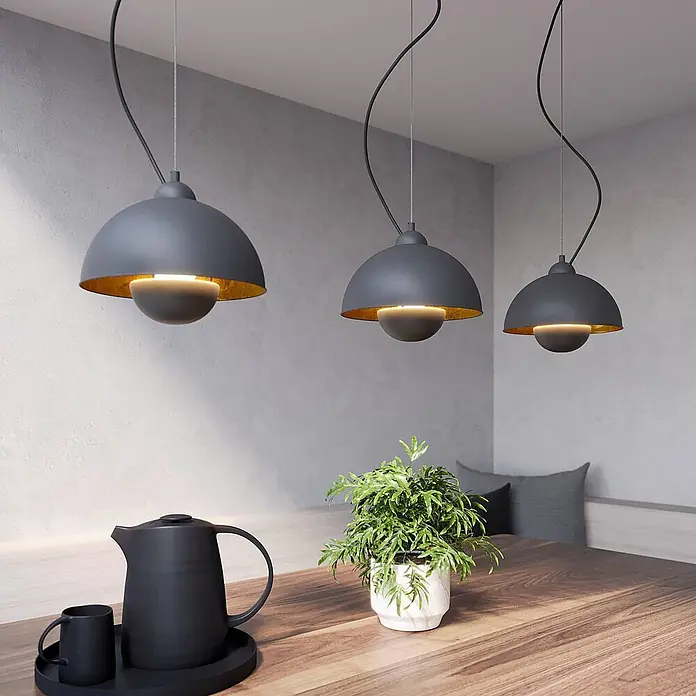 Lindby Pendelleuchte Gretja - L x B x H: 120,5 x 25 x 150 cm, schwarz, Schwarz, gold, E27 - Drei graue Hängelampen mit goldener Innenseite über einem Holztisch beleuchten einen modernen Essbereich.