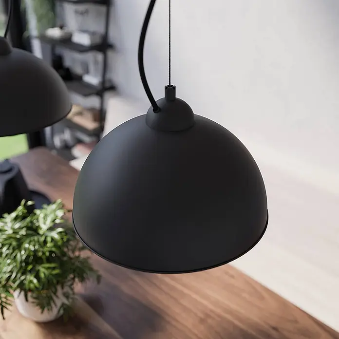 Lindby Pendelleuchte Gretja - L x B x H: 120,5 x 25 x 150 cm, schwarz, Schwarz, gold, E27 - Matte schwarze Metallkuppel-Pendelleuchte über einem Holztisch.
