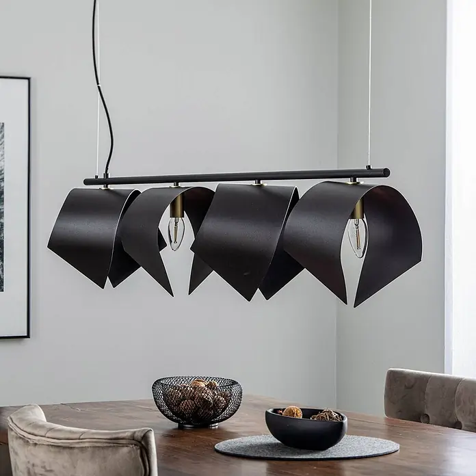 Lucande Pendelleuchte Mikolay - L x B x H: 118,5 x 22,2 x 23,5 cm, schwarz, sandSchwarz, E14 - Schwarze Pendelleuchte mit gefalteten Metallschirmen und sichtbaren Glühbirnen über einem Esstisch aus Holz.