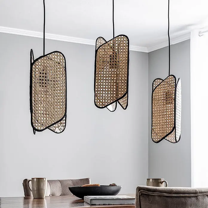 Lucande Pendelleuchte Bassiola - L x B x H: 100 x 19 x 37 cm, Holz hell, Schwarz, Holz hell, E27 - Drei gewebte Rattan-Pendelleuchten mit schwarzen Rahmen hängen über einem Esstisch.