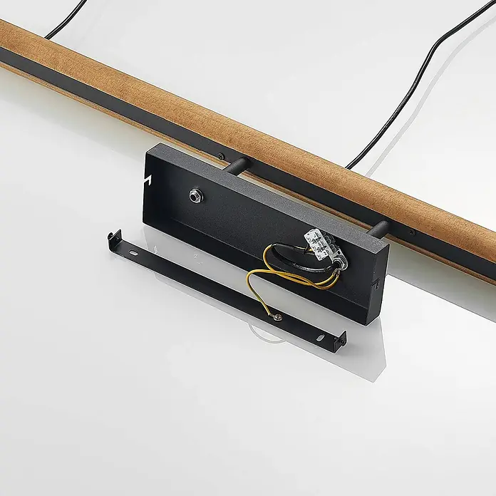 Lindby Pendelleuchte Flurin - schwarz, sandSchwarz, gold, holz, E27 - Interne Verkabelung (gelbe Drähte, transparenter Stecker) und Montagehalterung einer schwarzen Metall-Leuchte, daneben eine Holz-Lichtleiste.
