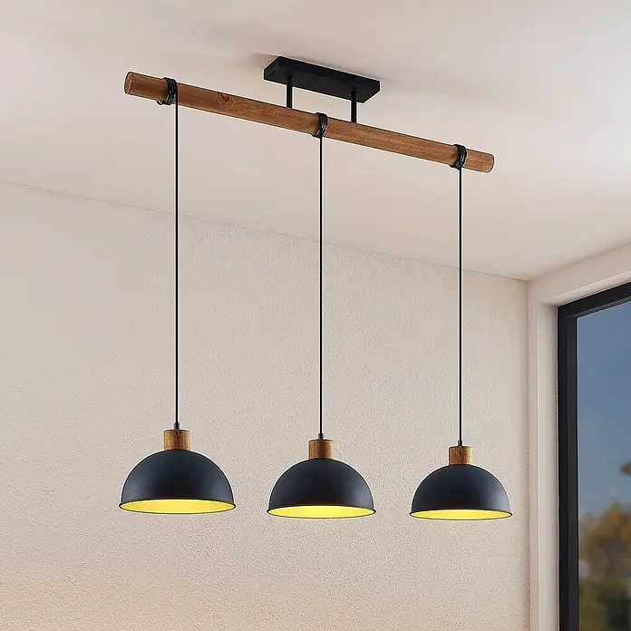 Lindby Pendelleuchte Flurin - schwarz, sandSchwarz, gold, holz, E27 - Hängelampe mit drei schwarzen Metallschirmen, Naturholzdetails und einer hölzernen Aufhängestange.
