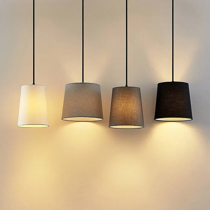 Lindby Pendelleuchte Hinai - L x B x H: 116 x 23 x 22 cm, weiß / opal, Holz hell, Schwarz, grau, weiß, E27 - Vier Stoff-Pendelleuchten hängen in einer Reihe, von Weiß bis Schwarz, und geben ein warmes Licht ab.
