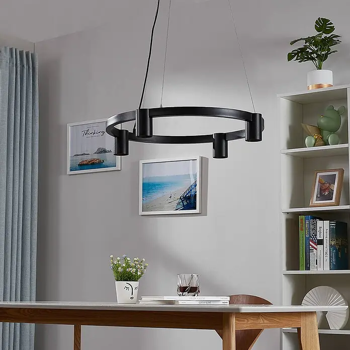 Arcchio Pendelleuchte Brinja - schwarz, Schwarz, GU10 - Schwarzer runder LED-Kronleuchter mit mehreren Strahlern hängt über einem Esstisch in einem modernen Raum.