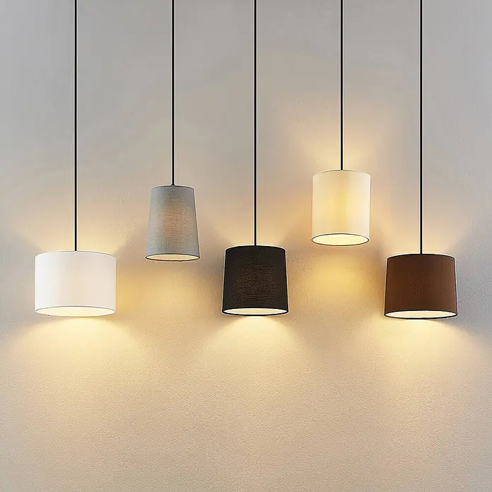 Lindby Pendelleuchte Amilia - Multicolour, Holz natur, Schwarz, grau, beige, braun, weiß, E27 - Fünf Hängelampen mit weißen, grauen, schwarzen, cremefarbenen und braunen Textilschirmen beleuchten eine Wand.