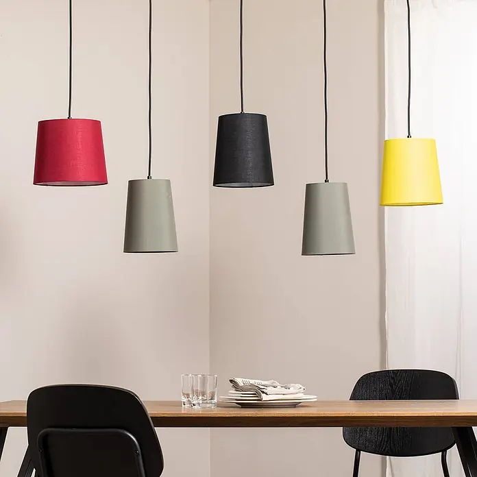 Lindby Pendelleuchte Amilia - L x B x H: 125 x 23 x 180 cm, Multicolour, Holz natur, Rot, grau, Schwarz, gelb, E27 - Fünf Pendelleuchten in roten, grauen, schwarzen und gelben Stoffschirmen hängen über einem Esstisch.