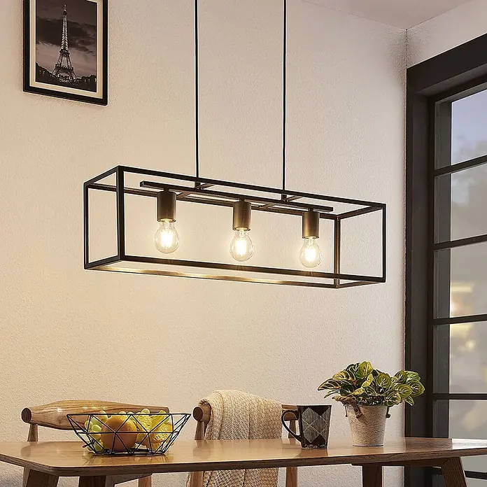Lindby Pendelleuchte Emily - L x B x H: 72 x 20 x 20 cm, schwarz, Schwarz matt, E27 - Schwarze rechteckige Pendelleuchte mit Messingdetails und drei Glühbirnen über einem Esstisch.