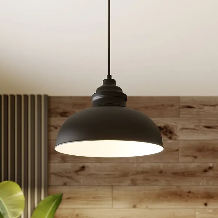 Lindby Pendelleuchte in schwarz matt, weiß, Hängelampe -  - Mattschwarze Metall-Pendelleuchte hängt beleuchtet in einem Raum mit Holzwänden und Pflanzen, die ein warmes Licht abgibt.