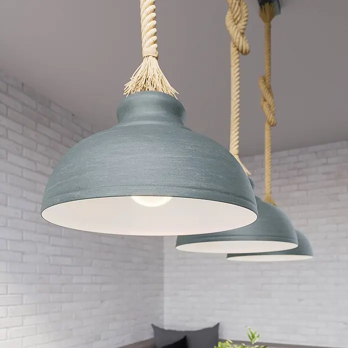 Lindby Pendelleuchte Chaby - alu / grau / zink, beton, E27 - Drei beleuchtete blaugraue Pendelleuchten mit Seilaufhängung hängen in einem modernen Interieur.