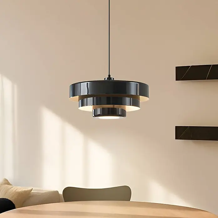 Lindby Pendelleuchte Tivra - schwarz, Schwarz, E27 - Gestufte Pendelleuchte in Schwarz und Messing über einem Tisch.