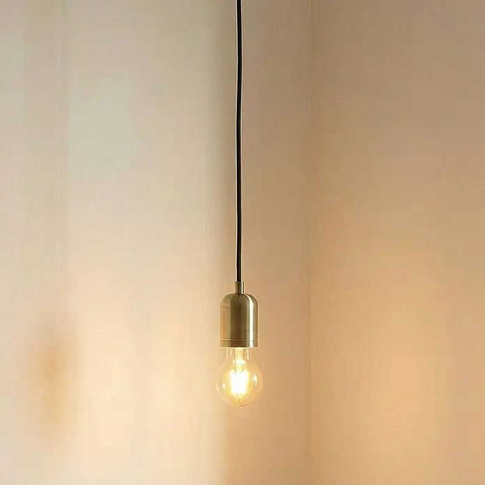 Lindby Pendelleuchte Hattie - L x B x H: 4,7 x 4,7 x 7 cm, messing / gold, messing, E27 - Messing-Pendelleuchte mit einer freiliegenden warmen LED-Birne in einer Zimmerecke hängend.