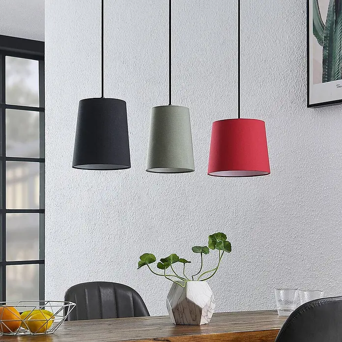 Lindby Pendelleuchte Amilia - L x B x H: 90 x 23 x 180 cm, Multicolour, Holz natur, Rot, grau, Schwarz, E27 - Drei Pendelleuchten mit Stoffschirmen in Schwarz, Salbeigrün und Rot, hängen über einem Esstisch.