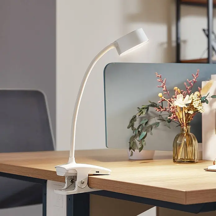 Lindby Klemmleuchte Maori - Farbe Gehäuse: weiß / opal - Weiß-klemmbare Schreibtischlampe mit flexiblem Hals, beleuchtet einen Holzschreibtisch im Büro.