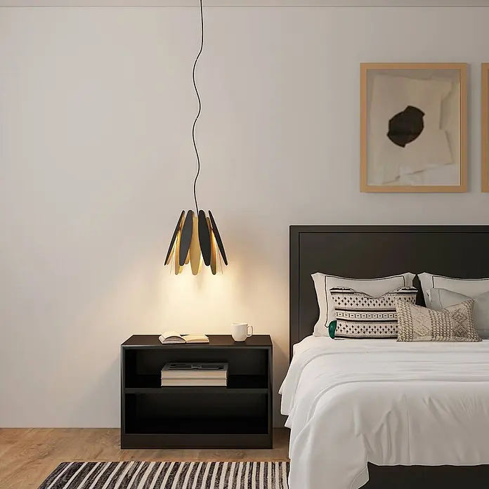 Lucande Pendelleuchte Lounit - schwarz, Schwarz, gold, E27 - Schwarz-goldene Hängeleuchte in Blütenform beleuchtet einen Nachttisch im Schlafzimmer.