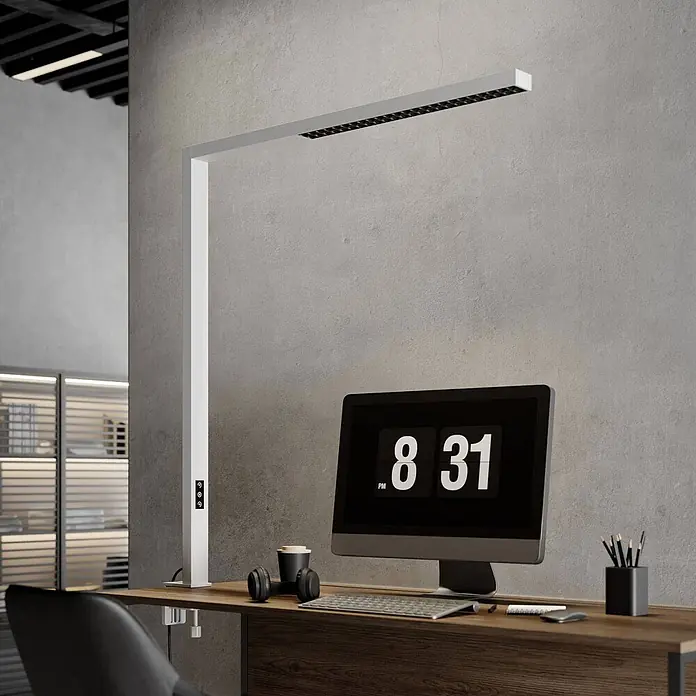 Arcchio Klemmleuchte Jolinda - Farbe Gehäuse: weiß / opal - Eine moderne weiße Schreibtischlampe mit LED-Leiste, am Holztisch befestigt. Sie beleuchtet den Arbeitsplatz mit Monitor und Kopfhörern.
