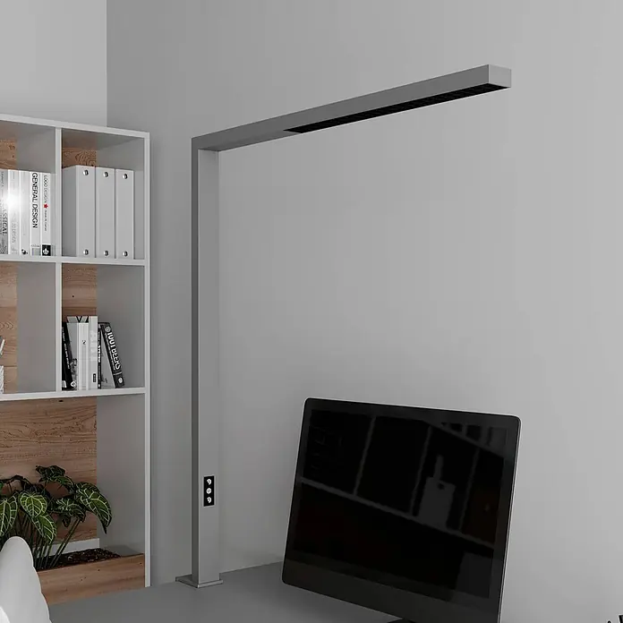 Arcchio Klemmleuchte Jolinda - Farbe Gehäuse: alu / grau / zink - Moderne graue L-förmige Schreibtischlampe mit integriertem LED-Streifen und Bedienelementen, beleuchtet einen Arbeitsplatz.