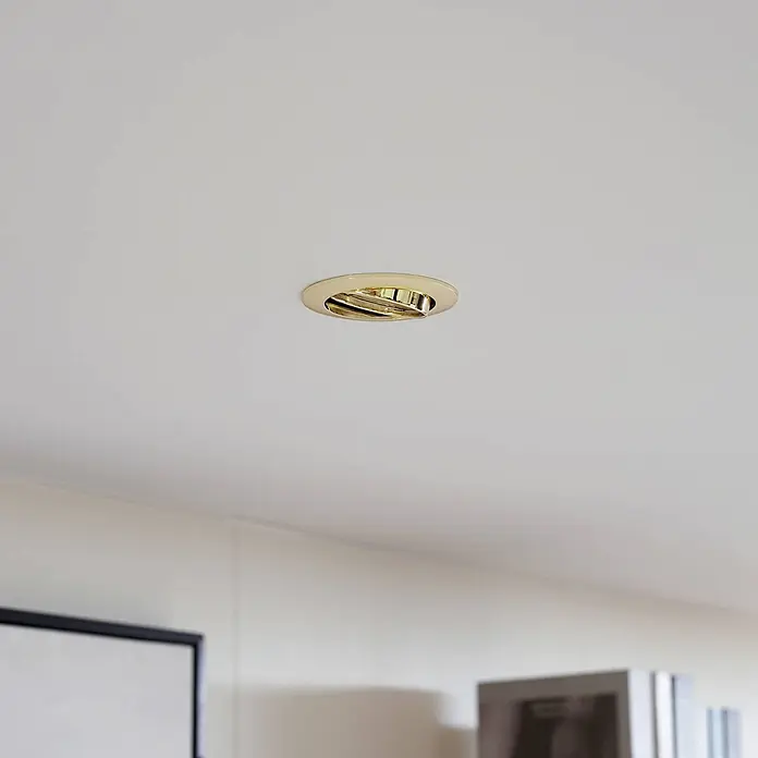 Prios Einbauleuchte Fibur - Ø x H: 8,2 x 2,8 cm, messing / gold - Goldener schwenkbarer Einbaustrahler in einer weißen Decke.