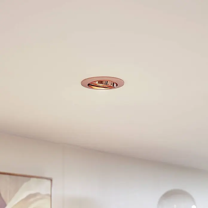 Prios Einbauleuchte Fibur - Ø x H: 8,2 x 2,8 cm, kupfer - Roségoldener Einbaustrahler in einer weißen Decke, der nach unten strahlt.