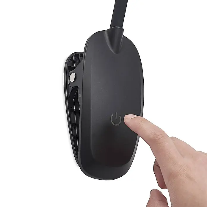 Prios Klemmleuchte Najari - Farbe Gehäuse: schwarz - Schwarze Klemmlampenbasis mit einem Finger, der den integrierten Ein-/Aus-Schalter drückt.