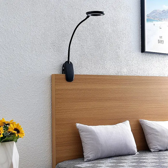 Prios Klemmleuchte Harumi - L x B x H: 14,8 x 11 x 51 cm, Farbe Gehäuse: schwarz - Schwarze Klemmleuchte mit flexiblem Arm und rundem Kopf, an einem Holz-Kopfteil befestigt.