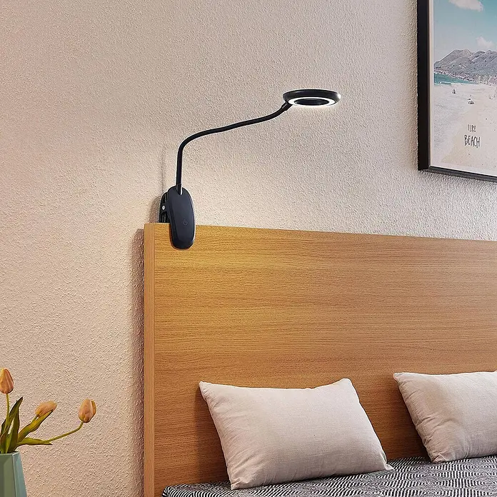 Prios Klemmleuchte Harumi - L x B x H: 14,8 x 11 x 51 cm, Farbe Gehäuse: schwarz - Schwarze Klemm-Leselampe mit flexiblem Arm und rundem LED-Licht an einem hellen Holzkopfteil befestigt, beleuchtet den Bereich.