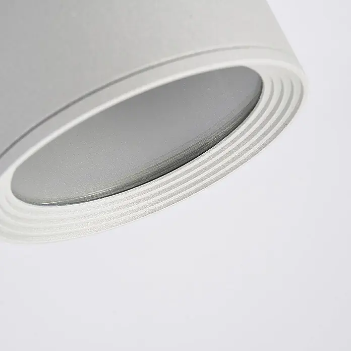 Lucande Außenwand- & Deckenleuchte Minna - alu / grau / zink, alu / grau / zink, IP54 - Nahaufnahme einer grauen zylindrischen Leuchte mit konzentrischen Ringen am metallischen Rand.