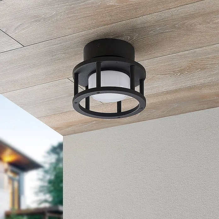 Lucande Außenwand- & Deckenleuchte Berenike - alu / grau / zink, alu / grau / zink, IP44 - Schwarze Outdoor-Deckenleuchte mit Metallkäfig-Design und weißem Diffusor, an einer hellen Holzpaneeldecke im Freien installiert.