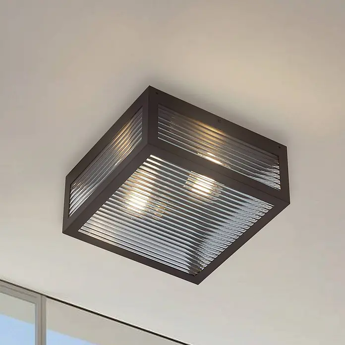 Lindby Außenwand- & Deckenleuchte Bolgar - schwarz, IP44 - Dunkelbraune quadratische Deckenleuchte mit gerippten Klarglaspaneelen, warmes Licht ausstrahlend.
