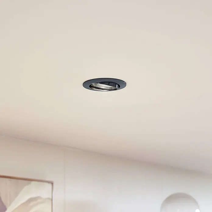Prios Einbauleuchte Fibur - Ø x H: 8,2 x 2,8 cm, alu / grau / zink - Dunkelgraue Decken-Einbauleuchte mit metallischem Inneren, in einer hellen Decke installiert.