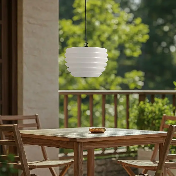 Lindby Außenwand- & Deckenleuchte Arona - weiß / opal, IP65 - Weiße, geschichtete Pendelleuchte über einem Holztisch auf der Terrasse hängend.