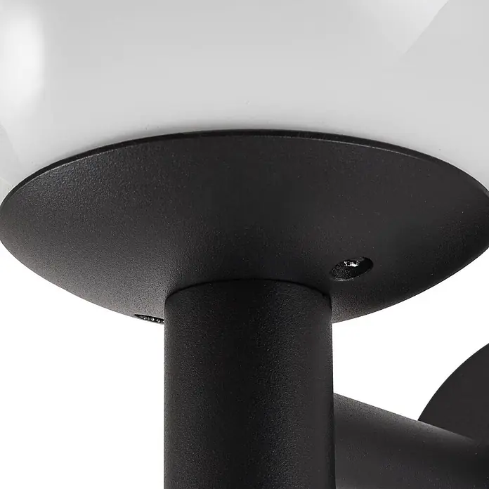 Lindby Außenwandleuchte Dangan - weiß / opal, IP44 - Schwarzer, texturierter Metallsockel einer Lampe, der mit einer weißen Kugel verschraubt ist.