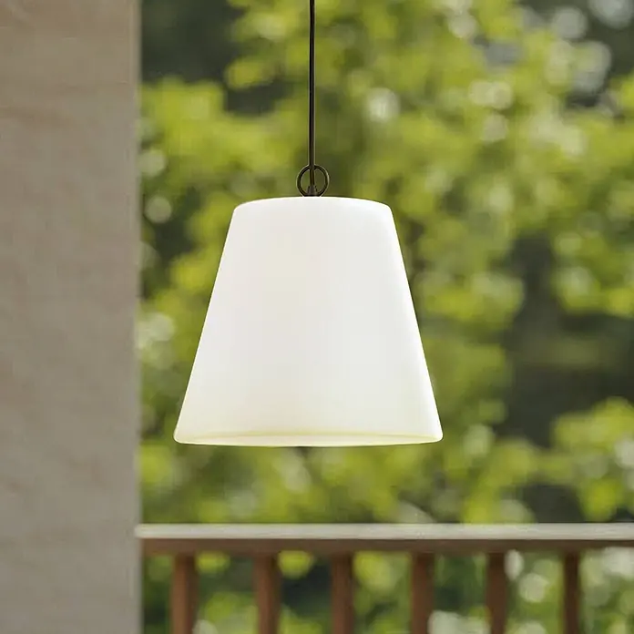 Lindby Außenwand- & Deckenleuchte Alaida - L x B x H: 35 x 35 x 30 cm, weiß / opal, IP65 - Weißes, konisch zulaufendes Pendellicht an dunkler Schnur vor unscharfem Outdoor-Hintergrund mit Grün und Holzgeländer.