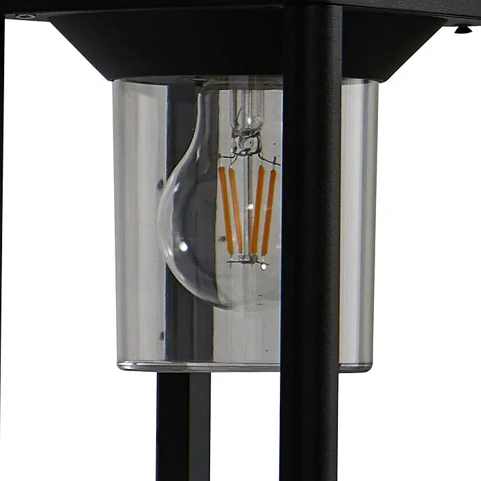 Lucande Außenwandleuchte Milanka - schwarz, schwarz, IP65 - Nahaufnahme einer schwarzen Außenleuchte mit klarem zylindrischem Glasschirm und LED-Filamentbirne.