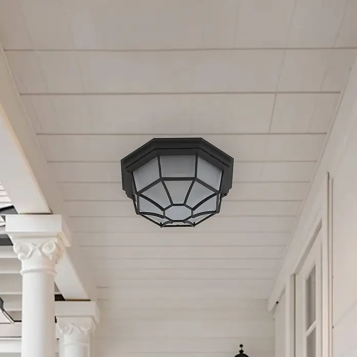 Lindby Außenwand- & Deckenleuchte Idril - schwarz, IP44 - Dunkle, achteckige Deckenleuchte mit geometrischem Käfig an einer weißen Verandadecke.