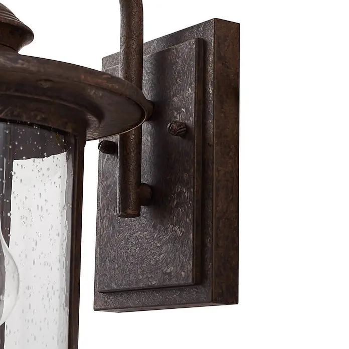 Lindby Außenwandleuchte Zayn - braun / rost, braun / rost, IP23 - Nahaufnahme einer dunkelbronzenen Außenwandleuchte mit gesätem Glas und Hammerschlag-Finish.