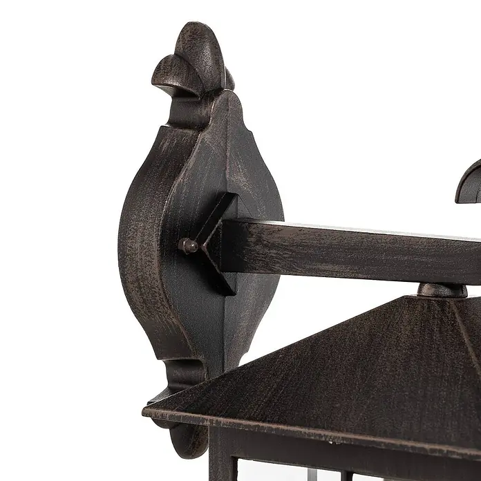 Lindby Außenwandleuchte Ida - braun / rost, braun / rost, IP23 - Außenwandleuchte aus patinierter Bronze, zeigt die dekorative Wandhalterung und den oberen Teil der Lampe.