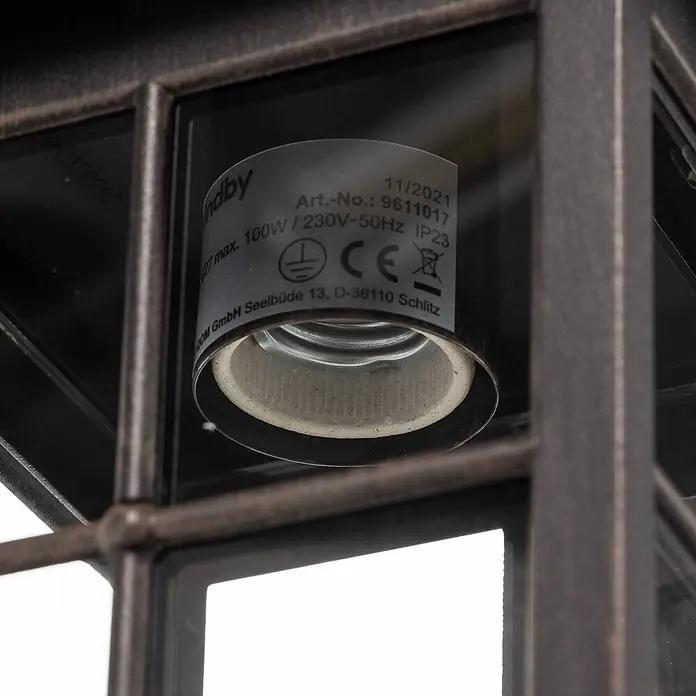 Lindby Außenwandleuchte Ida - braun / rost, braun / rost, IP23 - Nahaufnahme der E27-Fassung einer dunklen, gealterten Metall-Außenleuchte. Das Etikett zeigt max. 100W, 230V-50Hz, IP23.
