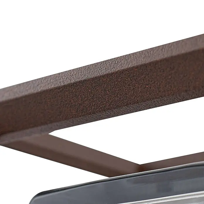 Arcchio Außenwandleuchte Ismera - braun / rost, braun / rost, IP65 - Nahaufnahme eines strukturierten, gesprenkelten braunen Metallrahmens über einer glatten, dunkelgrauen Oberfläche, Teil eines Möbelstücks.