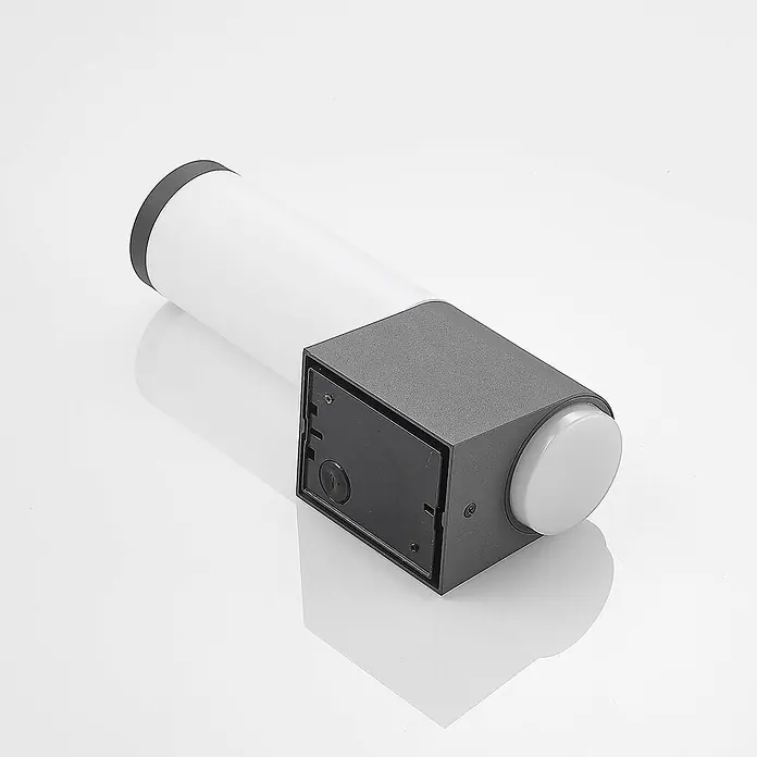 Lindby Außenwandleuchte Okari - schwarz, IP54 - Moderne dunkelgraue und weiße Außenleuchte. Verfügt über einen zylindrischen Diffusor und einen rechteckigen Sockel mit runder weißer Kappe.